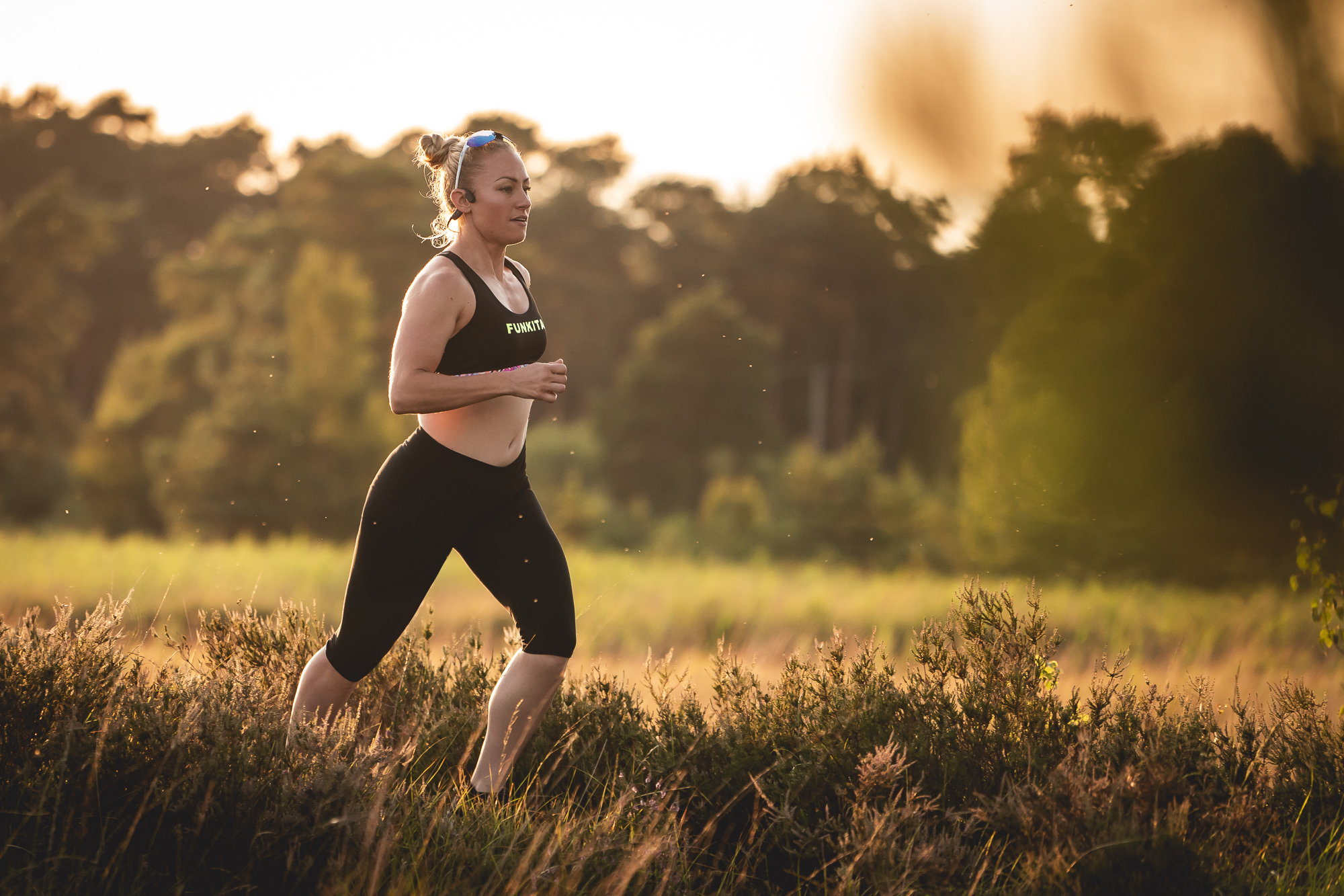 Runner training through sunlit heathland