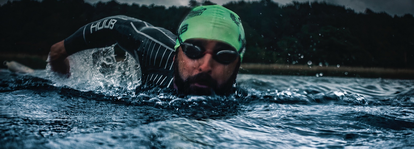 Open-water swimmer wearing goggles and a green cap