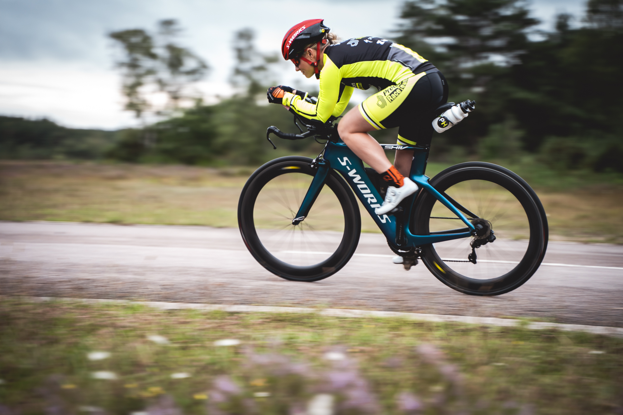 Triathlete riding in an aerodynamic position on a country road