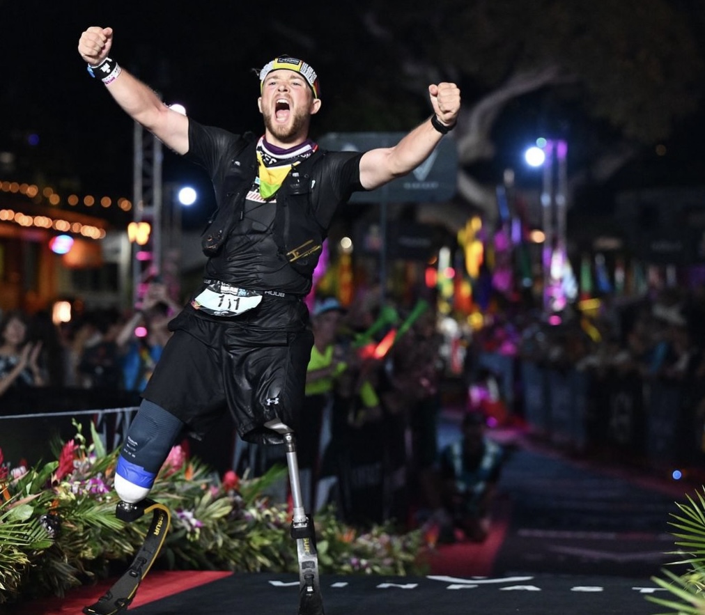 Billy celebrating at the finish line with both arms raised